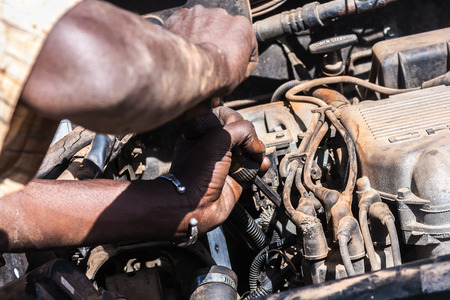 Close-up on an african man working on a broken car engine, Ouagadougou, Burkina Faso.