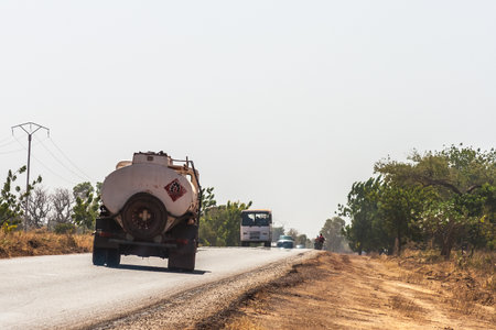 Fuel truck and traffic on the State Road 1 heading to Bobo-Dioulasso, Burkina Faso.のeditorial素材