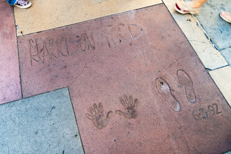 Handprints and footprints of the famous american actor Harrison Ford on the ground behind TCL Grauman's Chinese Theater, Hollywood Boulevard, Los Angeles, California.のeditorial素材