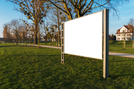 White clipped billboard in a park with the beautiful evening light - blank mockup -commercial and advertising conceptの写真素材