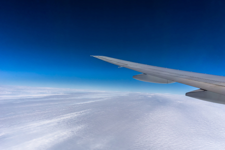 Flying over the clouds. Airplane wing with blue sky and copy space. Travel and transportation concept.の写真素材