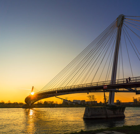 KEHL, GERMANY - MARCH 24, 2018: The Mimram Two-bank footbridge at sunset. This cable-stayed bridge considered as a modern artwork connects the banks of Germany and France between Strasbourg and Kehl.のeditorial素材