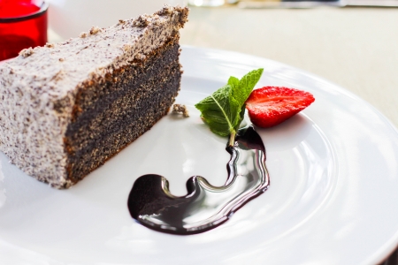 Delicious poppy seed cake with strawberry and chocolate sauceの写真素材