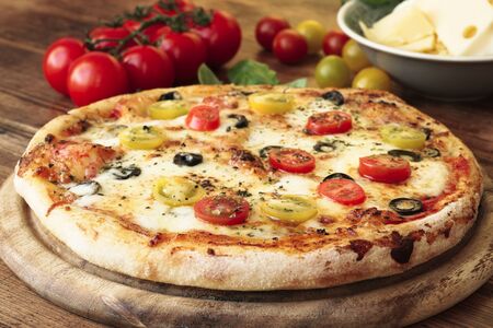 American pizza with tomatoes, olives, gouda cheese and mozzarellaの写真素材