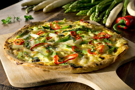 Homemade pizza with asparagus, red pepper, hollandaise sauce, mozzarella and fresh oreganoの写真素材