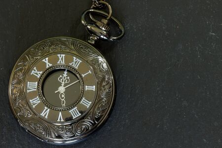 Close up of a pocket watch timepiece. Old clock with ornamental engravingsの写真素材