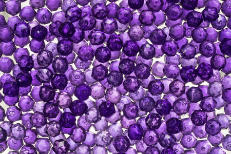 Close up of translucent purple crystals. Purple beads glittering and shining in the light
