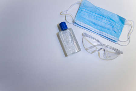 Protective equipment to protect against the covid-19 pandemic. Facemask, safety glasses and alcohol hand gelの写真素材