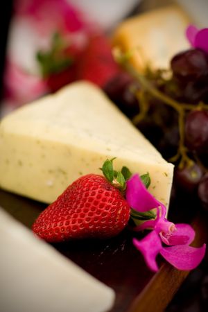An appetizer selection of cheese, crackers, grapes and strawberriesの写真素材