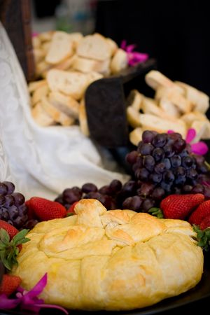 An appetizer selection of cheese, crackers, grapes and strawberriesの写真素材