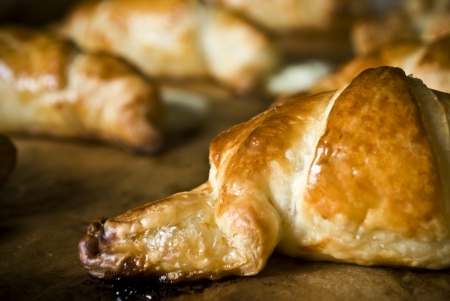 Fresh baked brown shiny and delicious croissant cake or pieの写真素材
