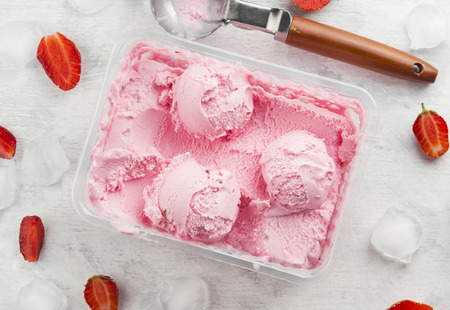 Strawberry ice cream in box on a white backgroundの写真素材
