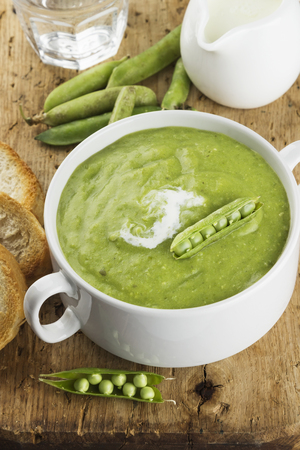 Green pea cream soup with toastsの写真素材
