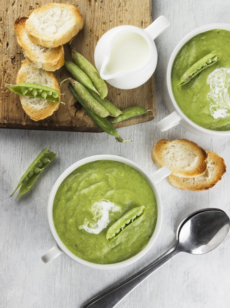 Green pea cream soup with toastsの写真素材