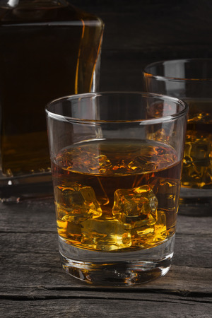 Whisky in two glasses on a dark wooden backgroundの写真素材