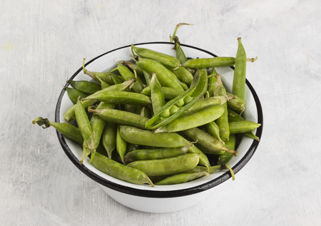 Green peas in metal bowls on a white backgroundの写真素材