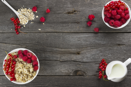 Oatmeal with raspberry and red currant on a wooden backgroundの写真素材