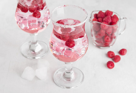 Summer cold drink with raspberry and ice on a white backgroundの写真素材