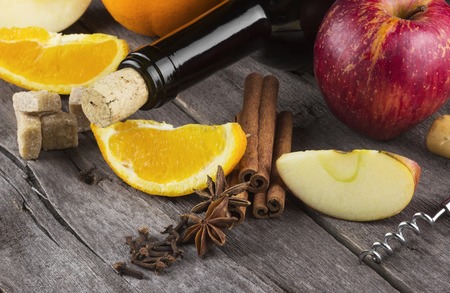 Ingredients for mulled wine - wine, cinnamon, carnation, apple, sugar, anise and orange on a wooden backgroundの写真素材
