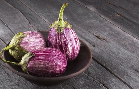 Harvest of eggplant graffiti on a dark wooden background.の写真素材