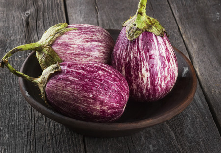 Harvest of eggplant graffiti on a dark wooden background.の写真素材