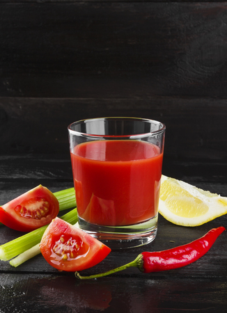 Bloody Mary with celery, lemon, hot pepper on a dark background.の写真素材