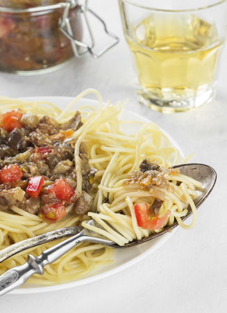 Spaghetti with eggplants and various vegetables on a white background.の写真素材