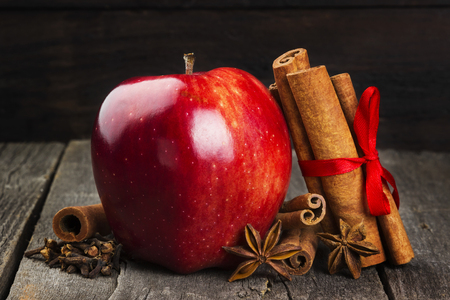 Apple, cinnamon, anisetree on a dark wooden background. Toningの写真素材