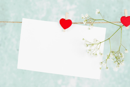 The love letter hangs on rope and a flower on a blue background. Toning.の写真素材