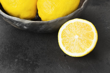 Lemons in clay bowl on a dark backgroundの写真素材
