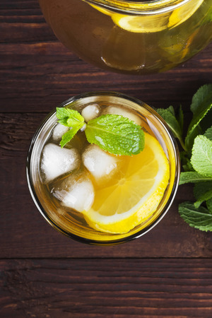 Ice tea with lemon and mint on a wooden background. Top view. Food backgroundの写真素材