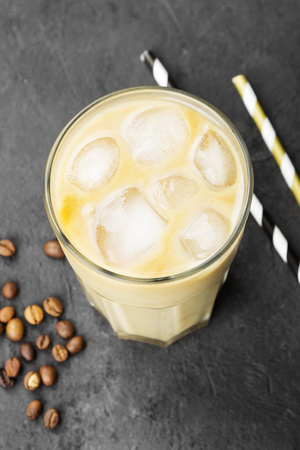 Ice coffee with milk in a tall glass on a dark backgroundの写真素材