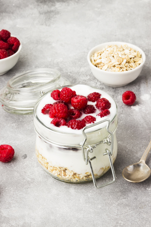 Glanola in glass jar with raspberry and mint on a gray backgroundの写真素材