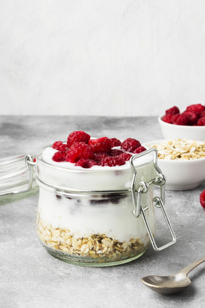 Glanola in glass jar with raspberry on a gray backgroundの写真素材