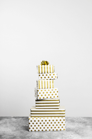 Group of gifts in white and gold paper on a gray backgroundの写真素材