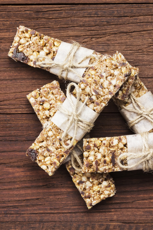 Cereal bars with nuts, berries and cinnamon on a wooden background. Top view, copy space. Food backgroundの写真素材