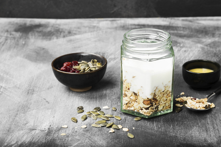 Granola with yogurt, honey, nuts, fruit on a dark background. Copy space. Food backgroundの写真素材