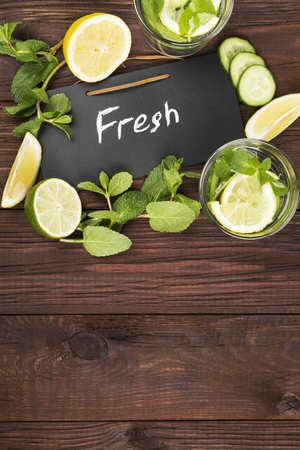 Detox drink with cucumber, lemon and mint on a wooden background. Top view, copy space. Food backgroundの写真素材