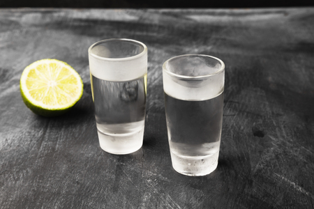 Cold vodka in shot glasses on a black backgroundの写真素材