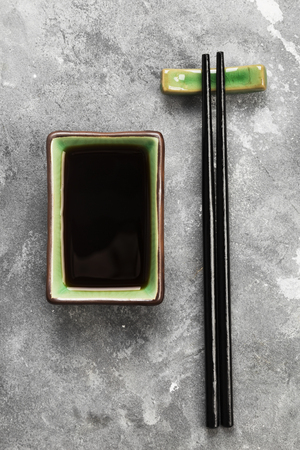 Soy sauce in traditional Asian ware on a gray background. Top view. Food backgroundの写真素材