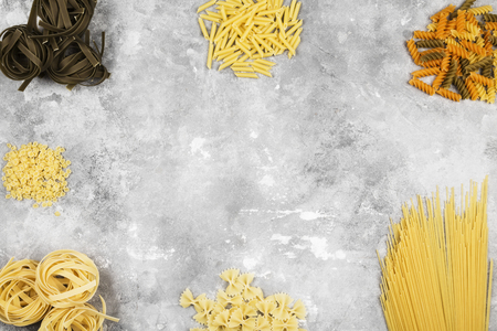 Various raw pasta on gray background. Top view; copy space. Food backgroundの写真素材