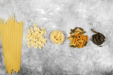 Various raw pasta on gray background. Top view. Food backgroundの写真素材