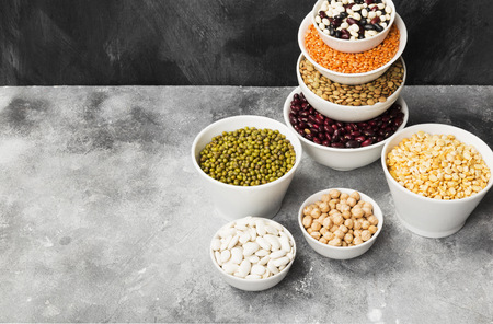 Assortment of beans (red lentil, green lentil, chickpea, peas, red beans, white beans, mix beans, mung bean) on gray background. Top view, copy space. Food backgroundの写真素材