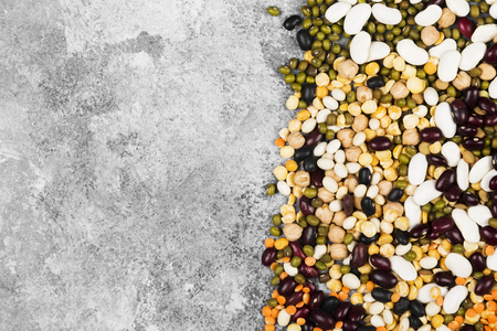 Assortment of beans (red lentil, green lentil, chickpea, peas, red beans, white beans, mix beans, mung bean) on gray background. Top view, copy space. Food backgroundの写真素材