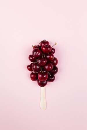 Ripe cherry in form of ice cream on a pink background. Top view. Food backgroundの写真素材