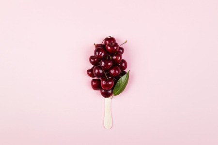 Ripe cherry in form of ice cream on a pink background. Top view. Food background