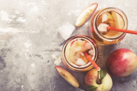Peach nectarine cold ice tea lemonad different ingredients two glasses jar on gray background.の写真素材