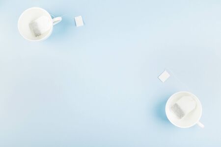 Cups of tea and tea bags on blue background. Top view, copy space. Food backgroundの写真素材