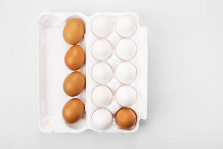 Group of raw eggs white and brown. Concept of diversity, isolation, racism, inequality. On gray background. Top viewの写真素材