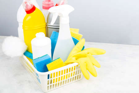 Various detergents and cleaning products agent, sponges, napkins and rubber gloves, gray background....